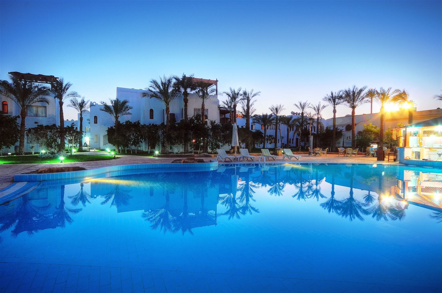 Twilight pool reflecting white residences